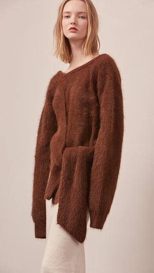 The Amuza Sweater in dark brown. Features chunky knit wrap-style sweater in dark brown alpaca and angora blend. Long sleeves, V-neckline (can be styled backward), self-tie wraps front around the waist, side slits. Pull on. Mid-weight. Oversized silhouette.