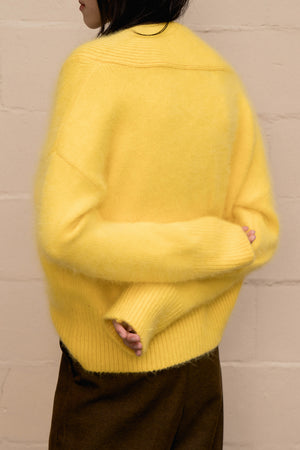 The Cecily angora sweater, long sleeved pullover with deep V-neck in yellow lambs wool blend. Dropped shoulder.