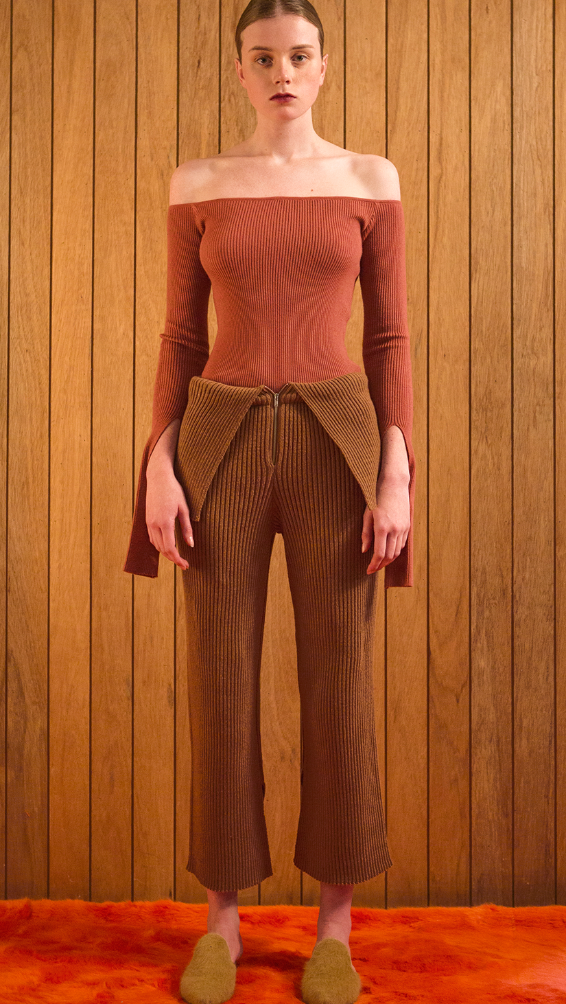 The Ellin OTS Sweater in Dusty Pink. Features off-the-shoulder silhouette with cut out cuffs. Pull on. Slim fit.