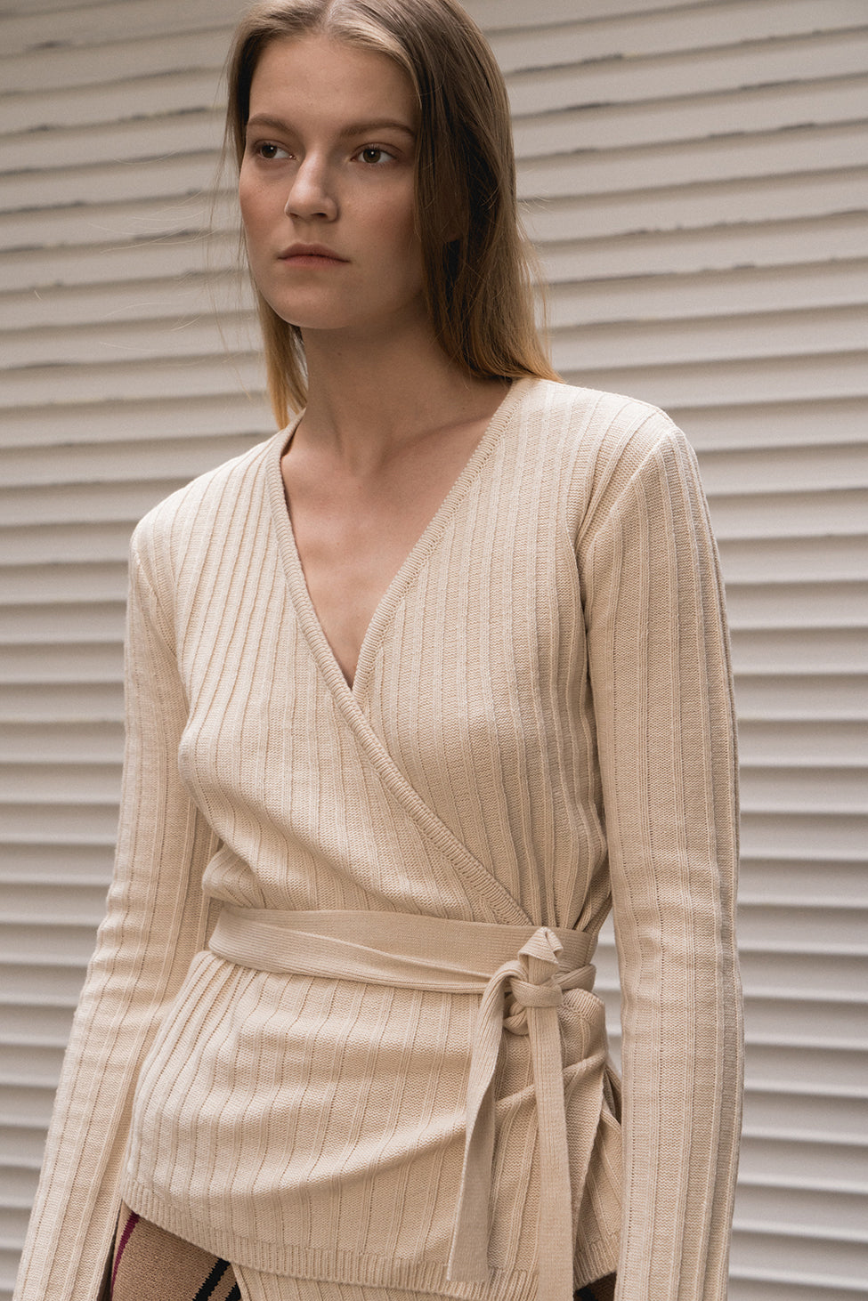 Wrap-around closure with front and tie fastening with deep V-neckline. Ribbed-knit.