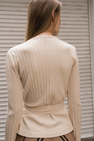 Wrap-around closure with front and tie fastening with deep V-neckline. Ribbed-knit.