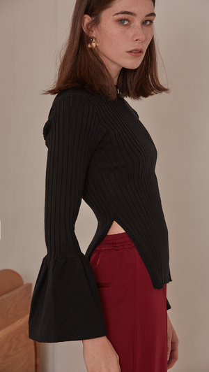 Etre Sweater in Black. Long bell sleeved rib knit in the avant-grade silhouette. Voluminous bell sleeves in cropped length top with side slit. Rounded hem. Super soft feel. Designed to skim the body.