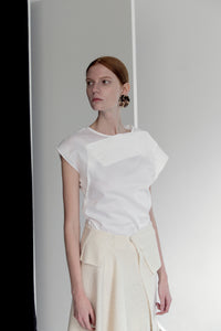 The Acre Top in white featuring cap sleeveless top with boat neckline, folded drape bodice detailing. Concealed zip down center back. 