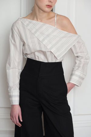 The Agate Top in White-and-Black stripe. Feature one-shoulder design with thin strap, asymmetric draped that sweeps across your décolletage and accentuates the collar. Button down closure along sleeves. 