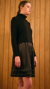 The Allyson Dress in black. Ribbed knit with a turtleneck and silky layered back with black stitching. Self-tie strap in angora. Slightly loose fit. Slips on.