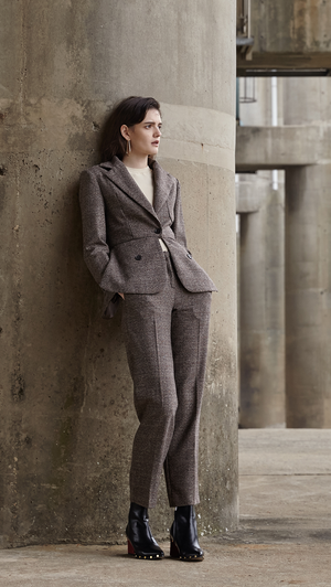 The Anouk Pant in brown, cream and black houndstooth pattern. With a sharply tailored that made from a soft wool-blend woven with a miniature houndstooth check. Side welt pockets. Sleek shape. 