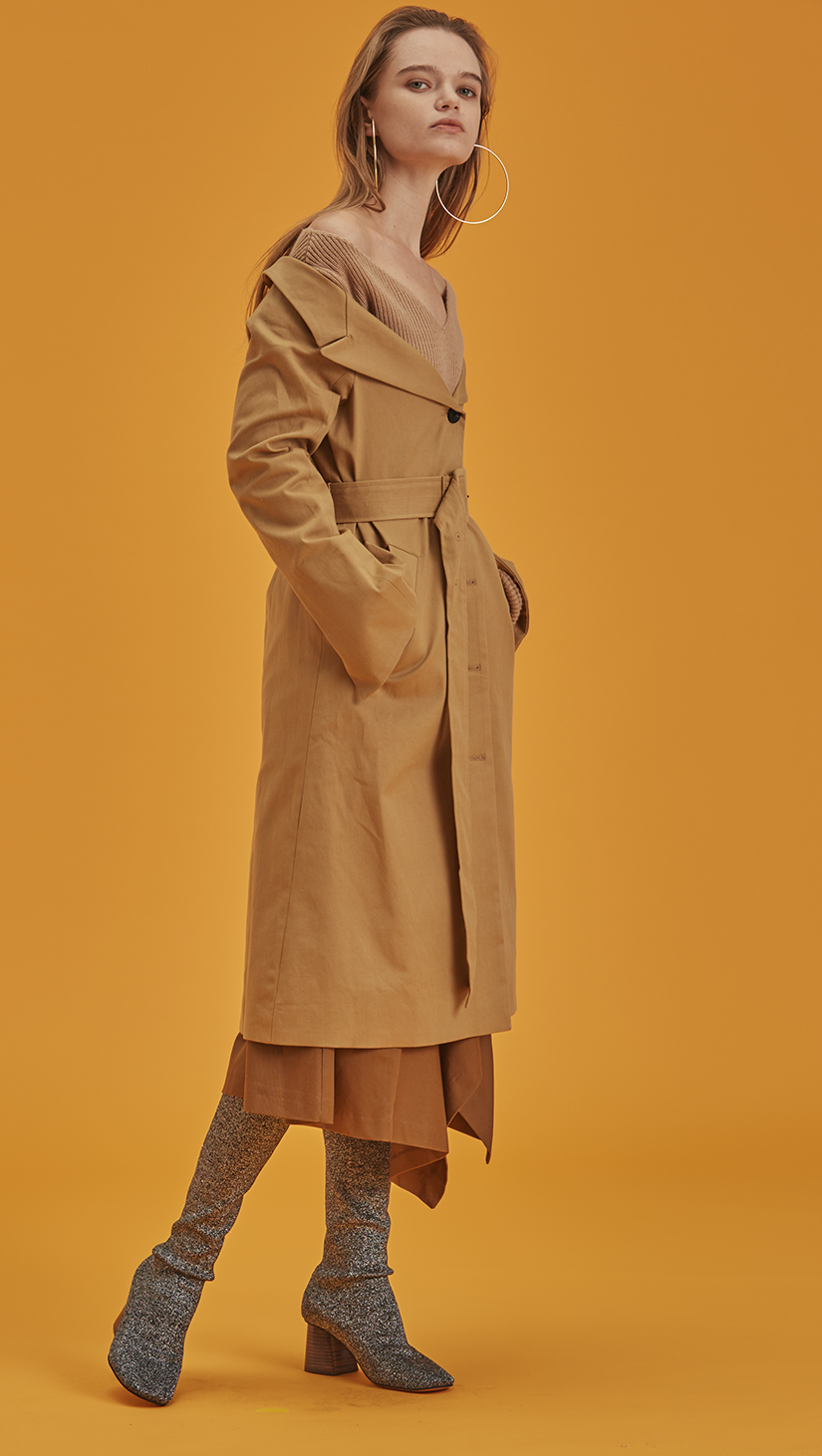 Archer is a trench coat in off-the-shoulder silhouette. With a detachable belt at waist, button down and pointed lapel collars, slip two pockets at natural waist. Designed to be off-the-shoulder. Straight hem. 
