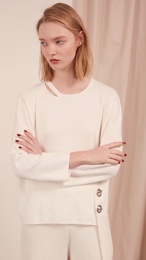 The Arie Sweater features round neck with cut out panel, asymmetric hem, back slit, sliver-tone hardware ring with hook closure. Pull on. Slightly relaxed fit.