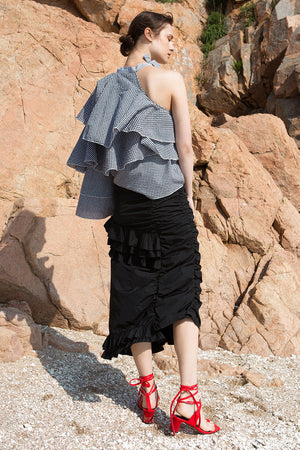 The Aurélie Skirt in Black featuring layered ruffles and cut on a bias. Asymmetrical hem. Concelaed side zip closure. Layered ruffles. Partial lined. High rise. 