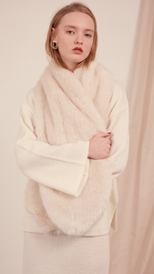 The Beaumont Scarf in faux fur. It features a cream ivory with a neat slip-through fastening and also can be layer it over the lapels of outerwear. 
