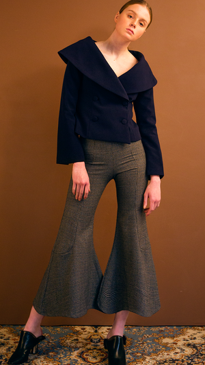 The Helena Pant is black houndstooth wide trouser sit high on the waist with an flared hem. Concealed zip closure along side. Wide leg cut. No pocket. Slim fit. Particularly wide hem.