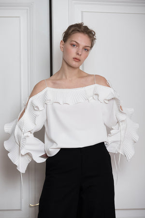 The Calin Top in White featuring thin straps, square neckline, dimple sleeves in ruffle detailing with self-tie. Pull on.