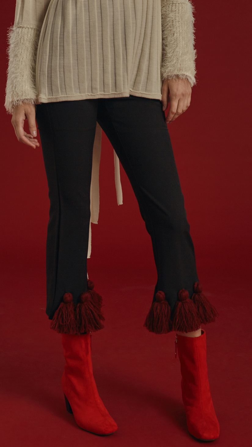 The Capoté Pant is mid-waisted, cropped black trousers with red tassles detailing in Burgundy. With button and zip closure at front, two pockets, ankle length. 