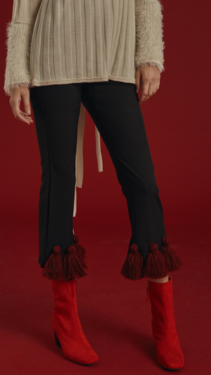 The Capoté Pant is mid-waisted, cropped black trousers with red tassles detailing in Burgundy. With button and zip closure at front, two pockets, ankle length. 