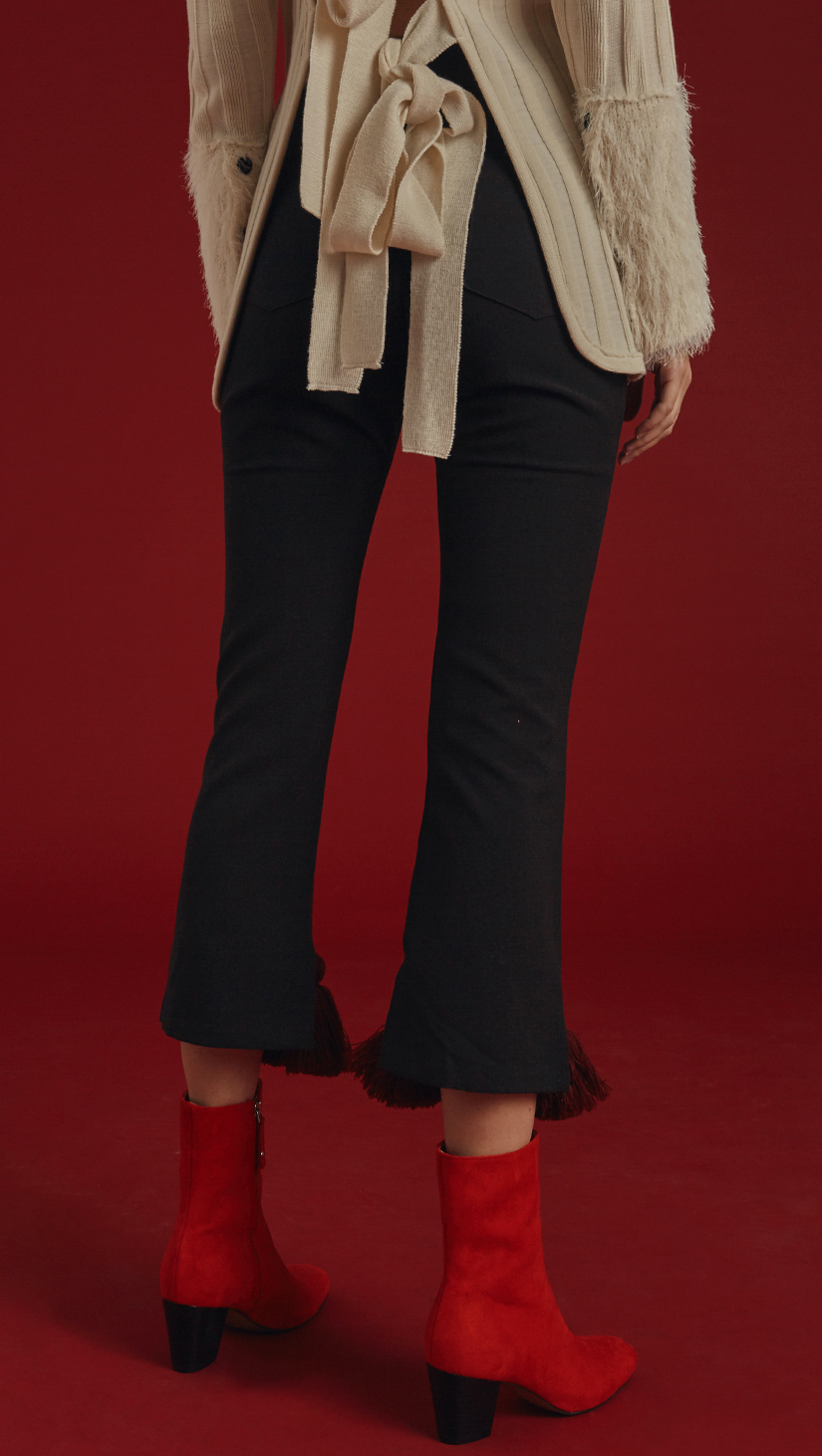 The Capoté Pant is mid-waisted, cropped black trousers with red tassles detailing in Burgundy. With button and zip closure at front, two pockets, ankle length. 