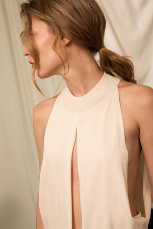 The Cecchetti Knit in Ivory, featuring mock neckline, deep slits at torso with cutout detail underneath. High-low hem. Straight silhouette. Please note that this is a fragile fabric. No returns will be accepted.