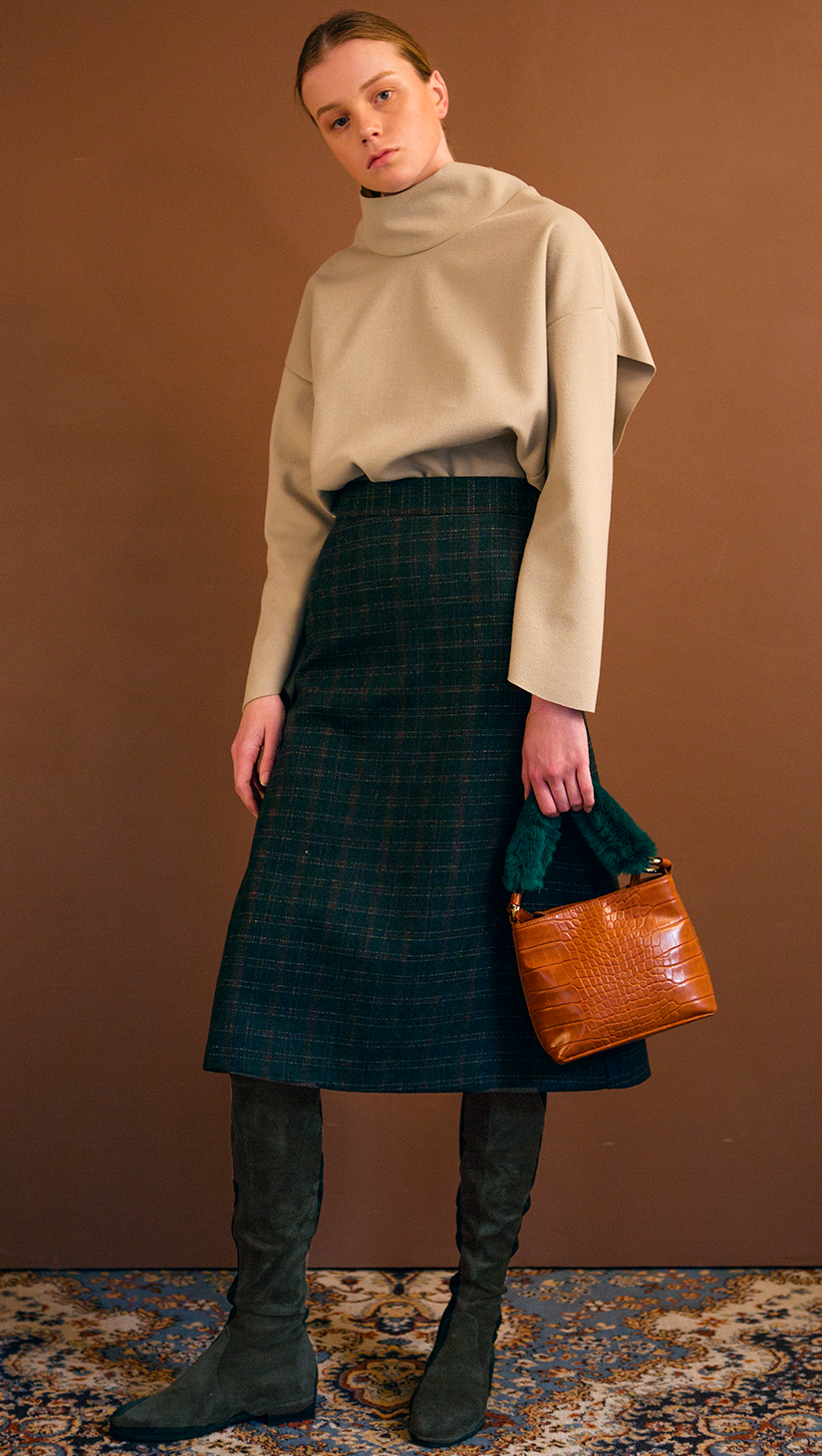 The Charlie Skirt in patterned with green plaid. With a high-waisted polished A-line style with back ruffle details. Over-the-knee length. Concealed zip closure. No pockets.