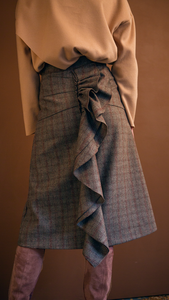 The Charlie Skirt in patterned with grey plaid. With a high-waisted polished A-line style with back ruffle details. Over-the-knee length. Concealed zip closure. No pockets.