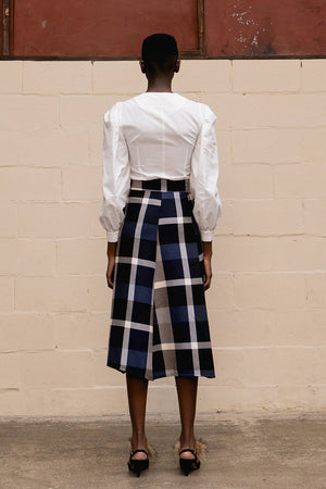 The Charron skirt featuring high rise, thick belted detail with large square ring. A-line silhouette. Concealed zip closure along side. Unlined. Mid-length. 