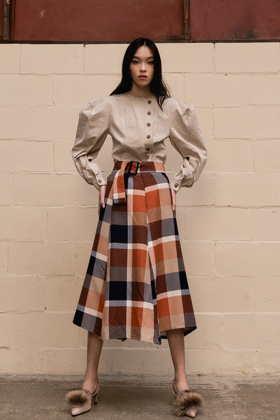 The Charron skirt featuring high rise, thick belted detail with large square ring. A-line silhouette. Concealed zip closure along side. Unlined. Mid-length. 