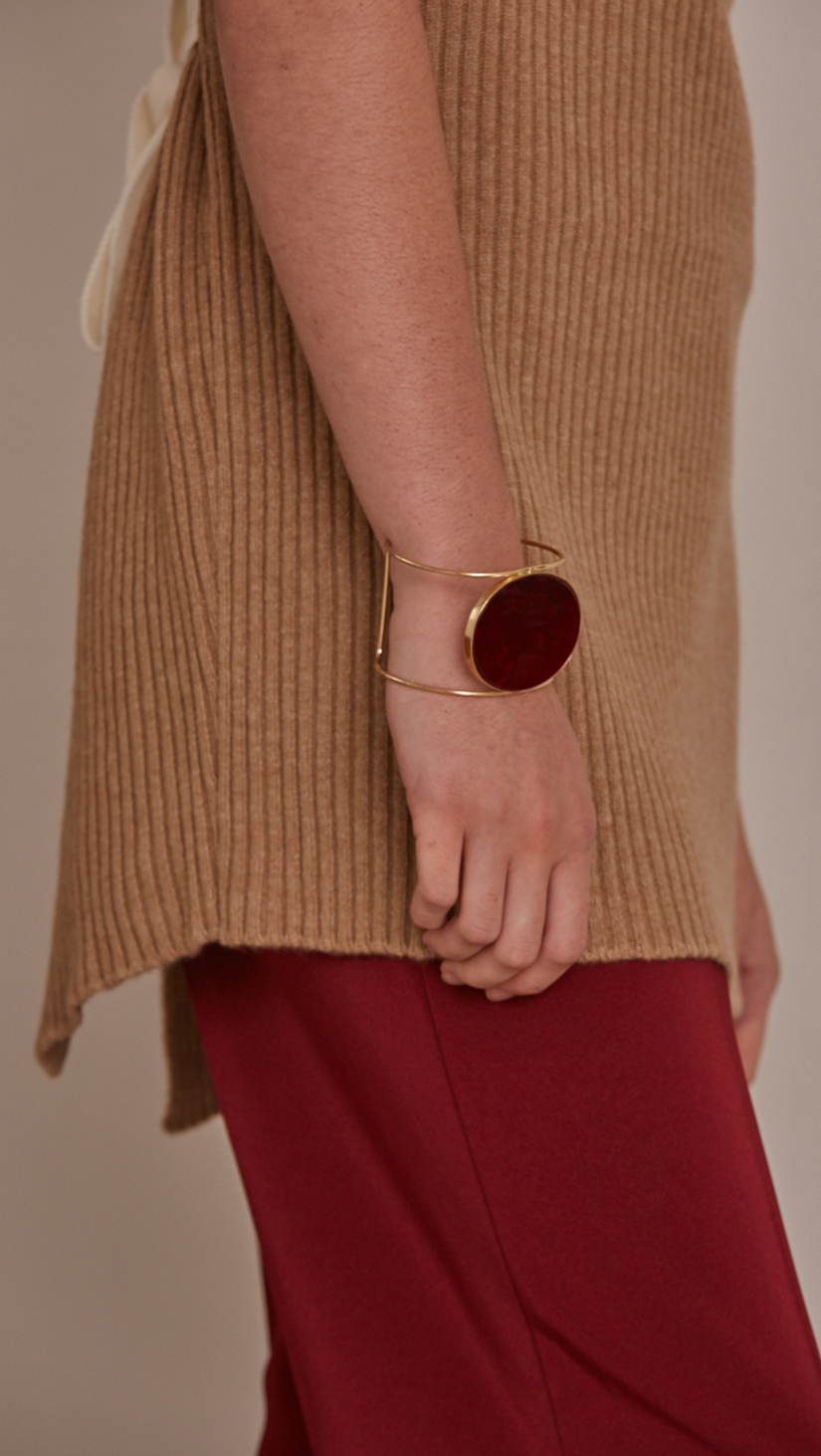 Claudé Bracelet, gold plating cuff with free moving burgundy marble discus circle.
