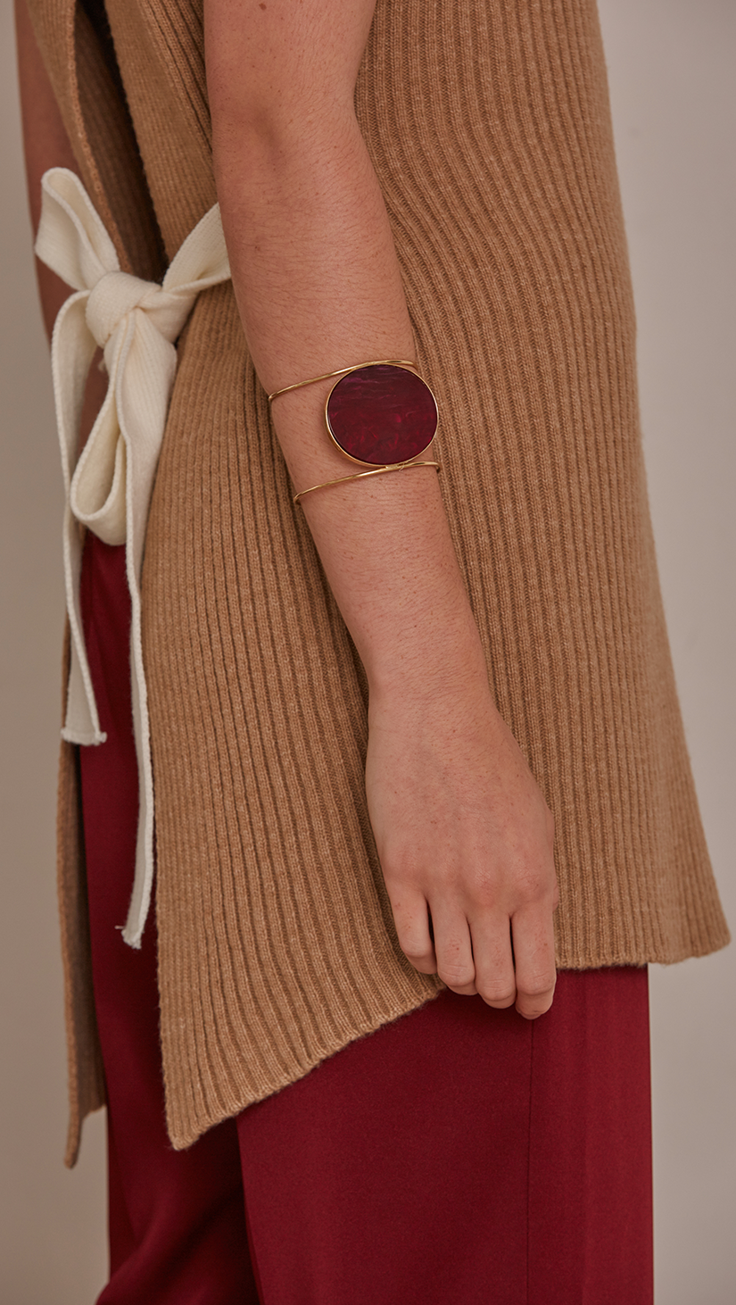 Claudé Bracelet, gold plating cuff with free moving burgundy marble discus circle.