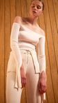 The Ellin OTS Sweater in Ivory. Features off-the-shoulder silhouette with cut out cuffs. Pull on. Slim fit.