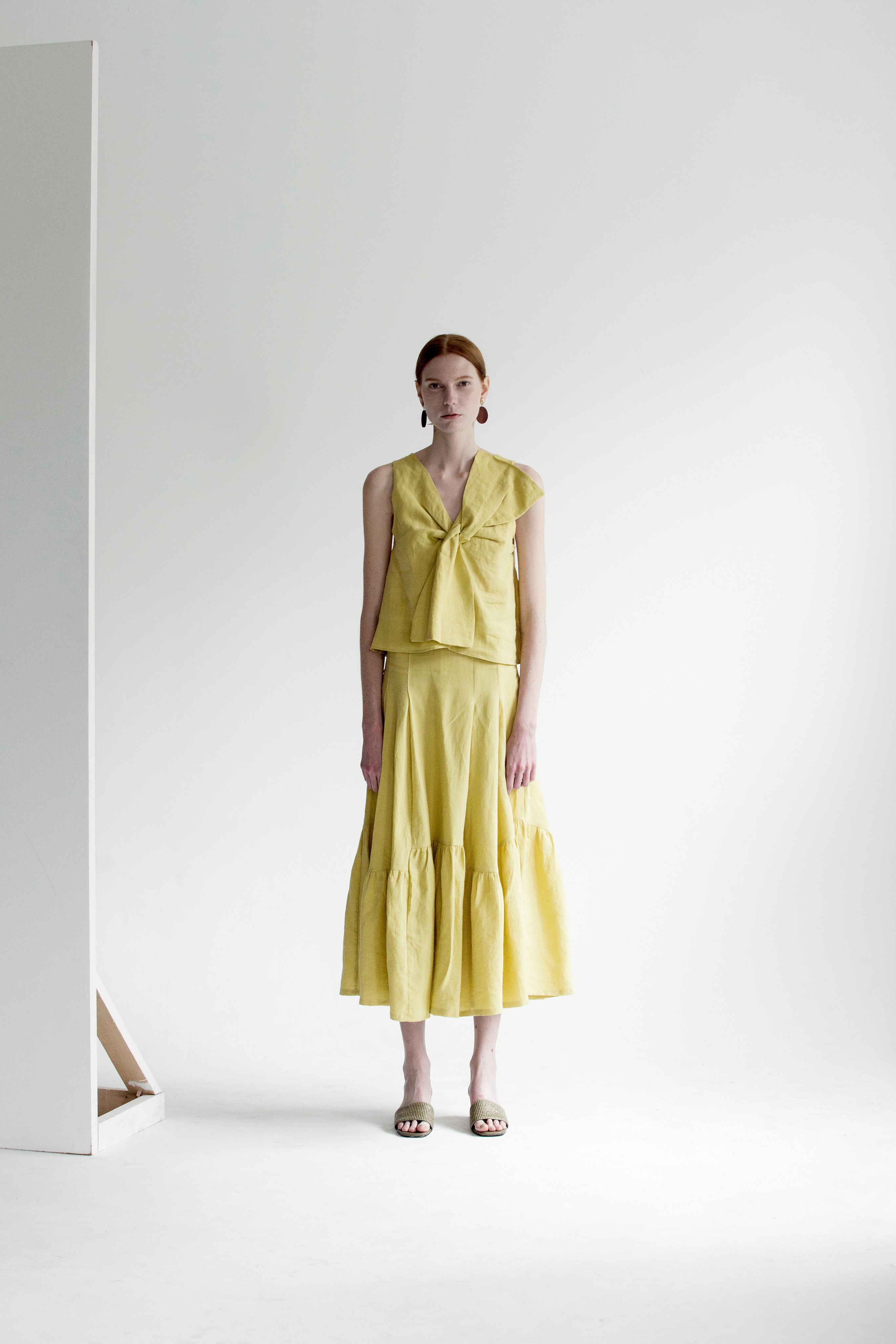 The Dhara Top in Chartreuse featuring sleeveless, V-neckline, front tuck detailing. Pull on.