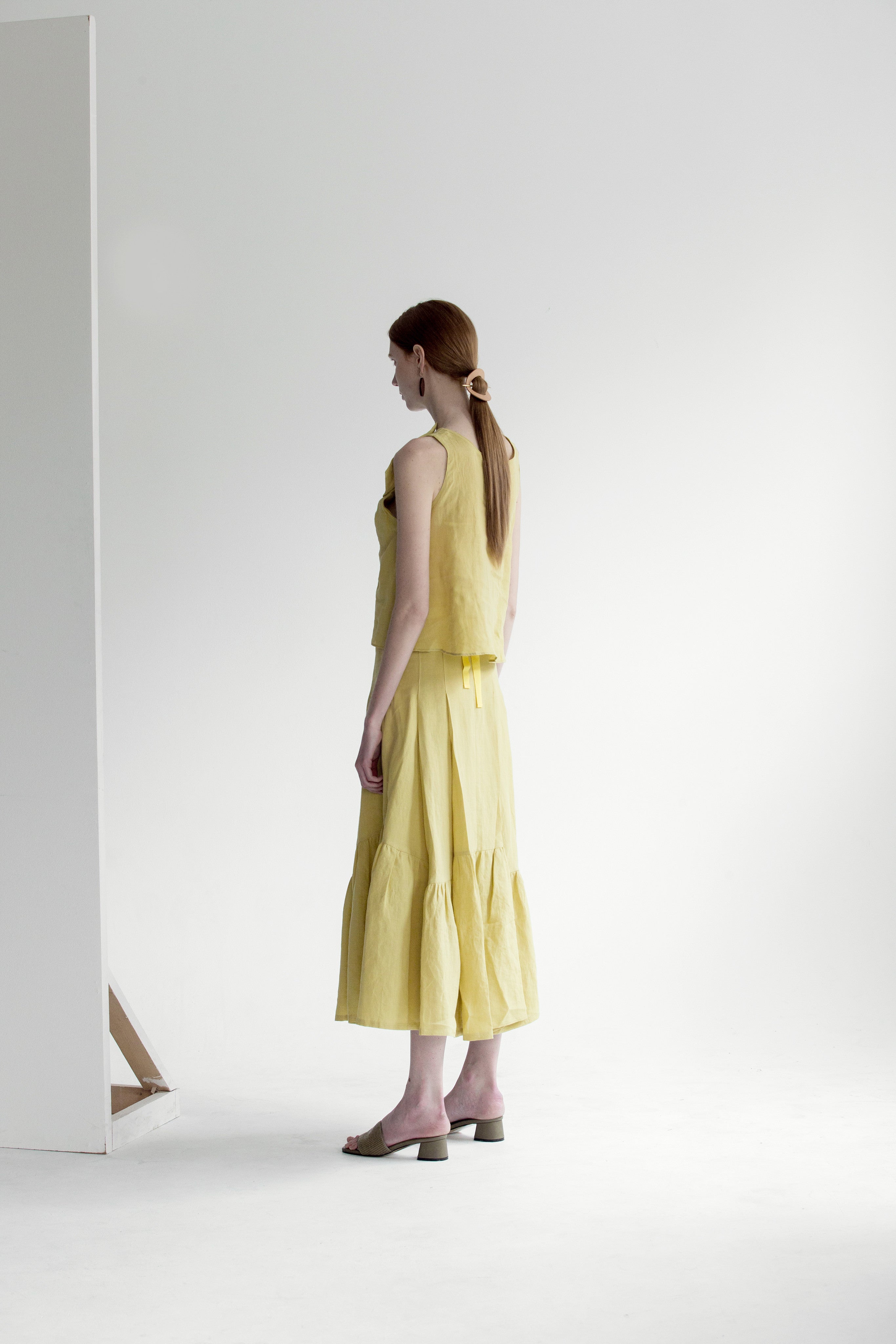 The Dhara Top in Chartreuse featuring sleeveless, V-neckline, front tuck detailing. Pull on.
