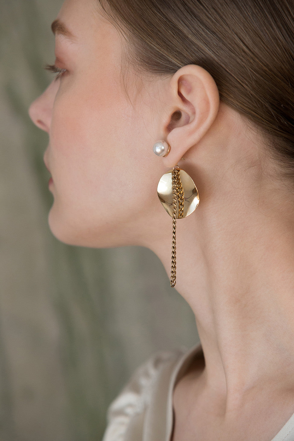 The Élio, a pair of an abstract eggshell-shaped design with gold chain.  Post back. Sold as a set.