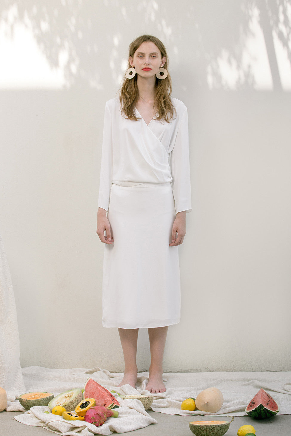 The Emmeline Skirt in White featuring fluted hem and elasticated waistband at back. Side slits. No pockets. Partial lined.