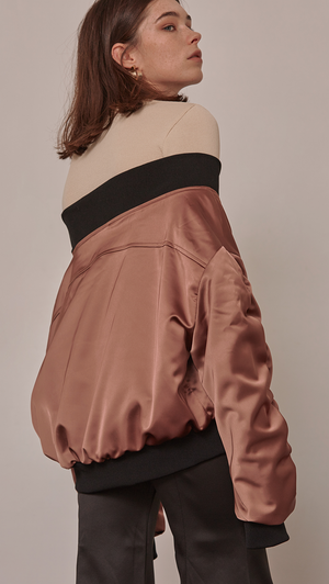 Farrow Off The Shoulder Bomber Jacket in Gold. Lustrous gold satin with oversized long ruched sleeves. Elastic off-the-shoulder banding. Front slit pockets. Zip fastening through front. Fully lined. Mid-weight. Designed to be loose fit. 