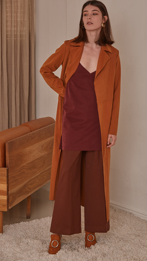 Vegan suede robe coat with tie in camel. No hardware, centre front tie closure. Pointed lapel collar and two oversize slip pockets at natural waist. Super soft suede feel. Straight hem. Designed to skim the body and have a dropped shoulder seam.