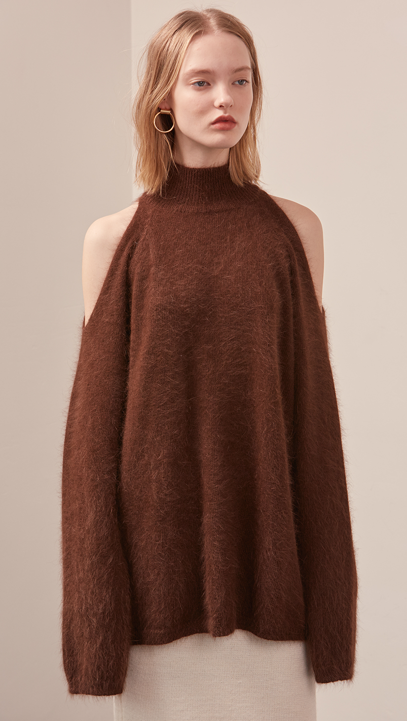 The Fella Sweater in dark brown. Features rolled neckline, long sleeves, drop shoulder, side slits. Pull on. Relaxed silhouette.