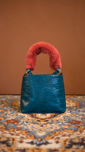 Forziéri bag in blue/pink. Fur handle, front flap magnetic snap tab closure. Interior pockets. Detachable shoulder straps. Structured bottom.