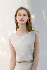 The Janelle Top in Beige featuring sleeveless tank top, deep U-neckline at back, button down closure at back.