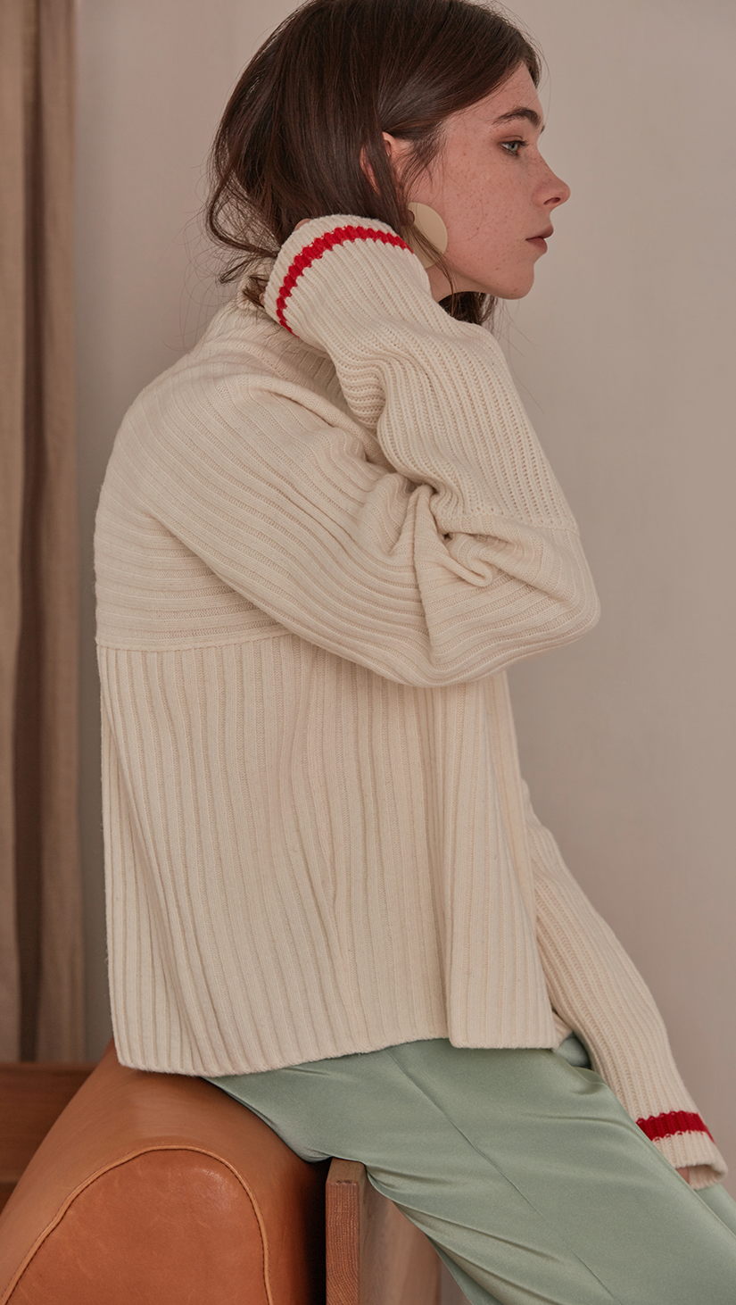 Jupe Sweater in Ivory. Cowl neck ribbed sweater with pointed dropped shoulder seams and extra long sleeves. Designed to be loose fit.  