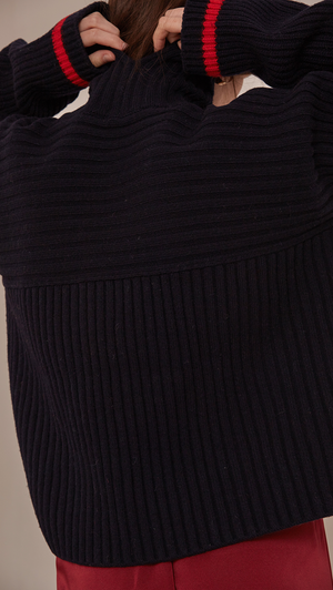 Jupe Sweater in Navy. Cowl neck ribbed sweater with pointed dropped shoulder seams and extra long sleeves. Designed to be loose fit.