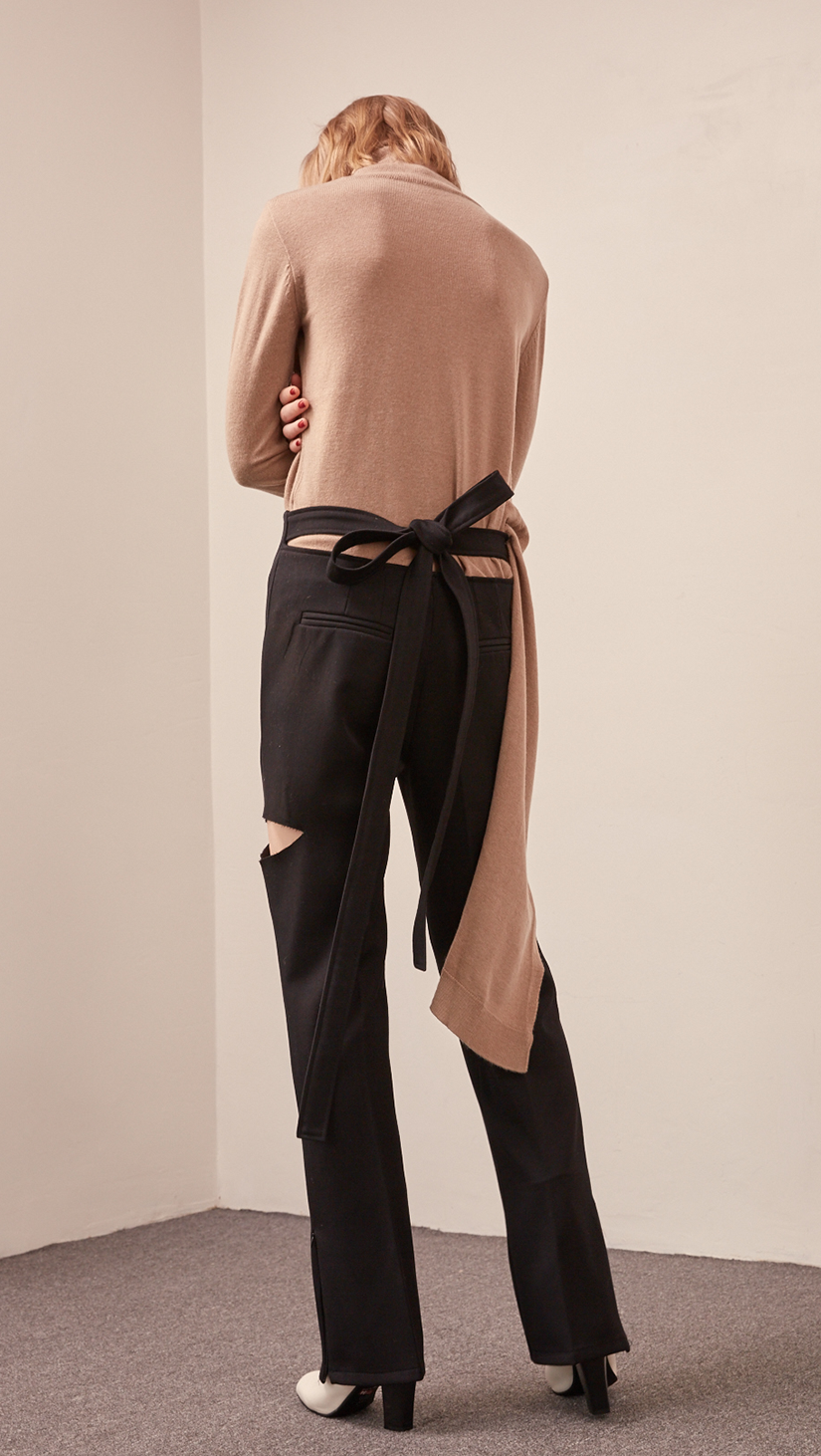 The Luna pant in back open with self-tie, cut out detailing and zip opening at hem. Zip fastening along side. High rise.