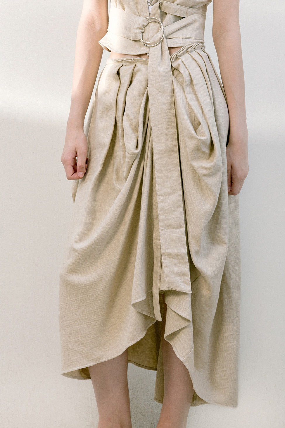 The Keria skirt in draped front skirt with detachable sash belt. Concealed back zip closure. Mid length. 