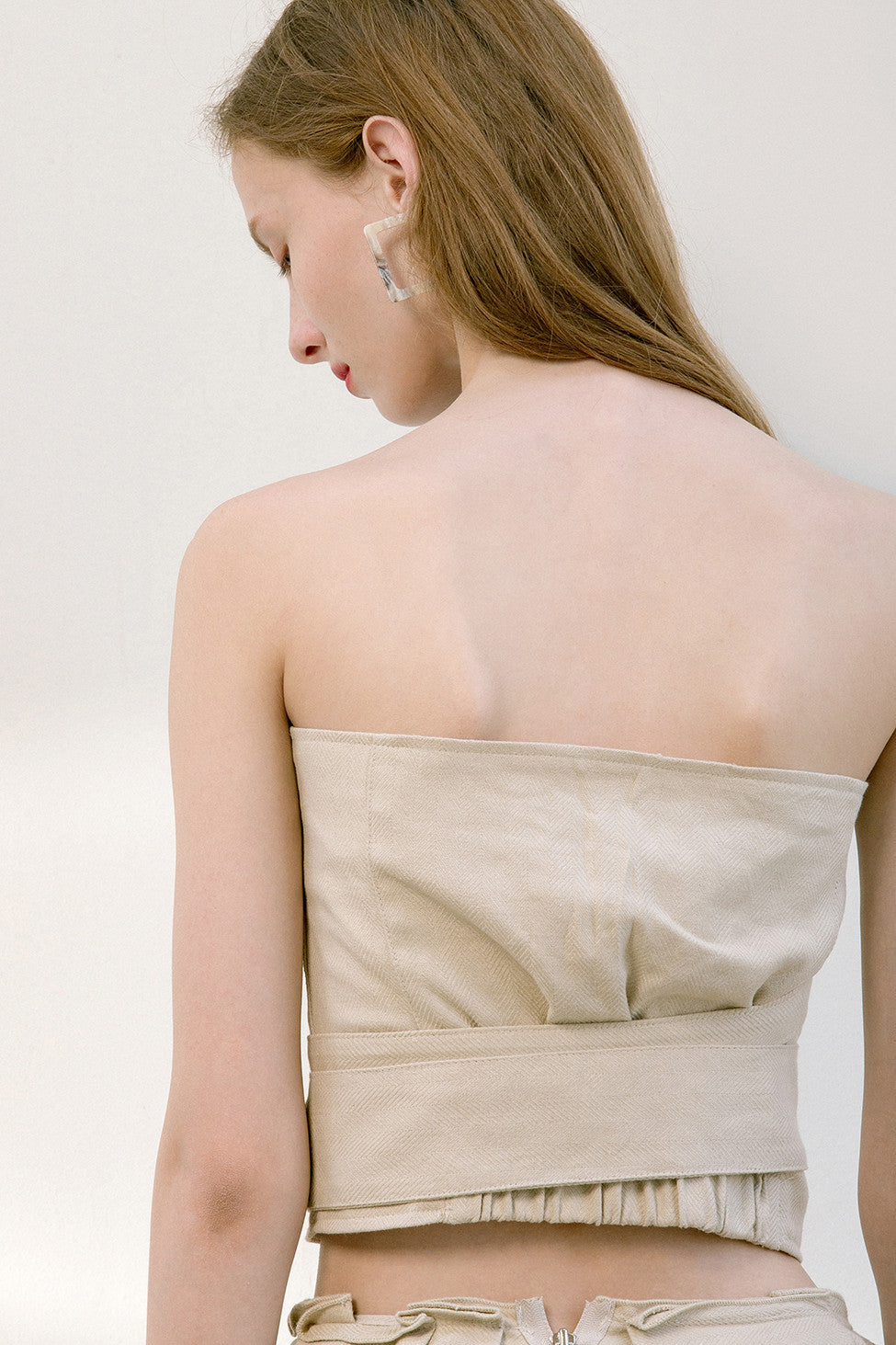 The Keria top in bustier with hook and eye front closure with attached sash belt. Partial elasticated band at back.
