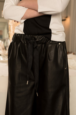 The Kuri Pant in Black featuring elasticated waistband with drawstring, slanted two pockets. Wide-leg silhouette. 