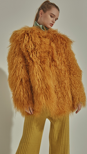 The Lellyn Fur Coat in Mustard. Exaggerated furry long sleeves, hook and eye closure. Oversized fit. Fully lined.