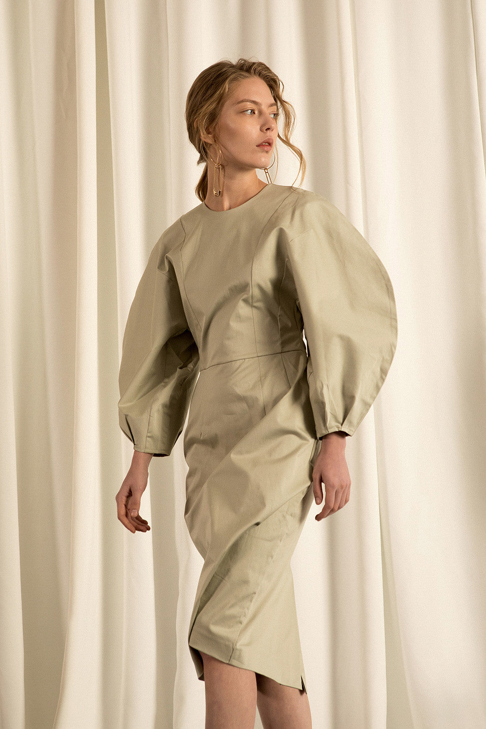 The Leyla dress in Olive, featuring round neckline, long puff sleeves with raglan detail at cuff, concealed zip fastening at the back. Fitted bodice. 