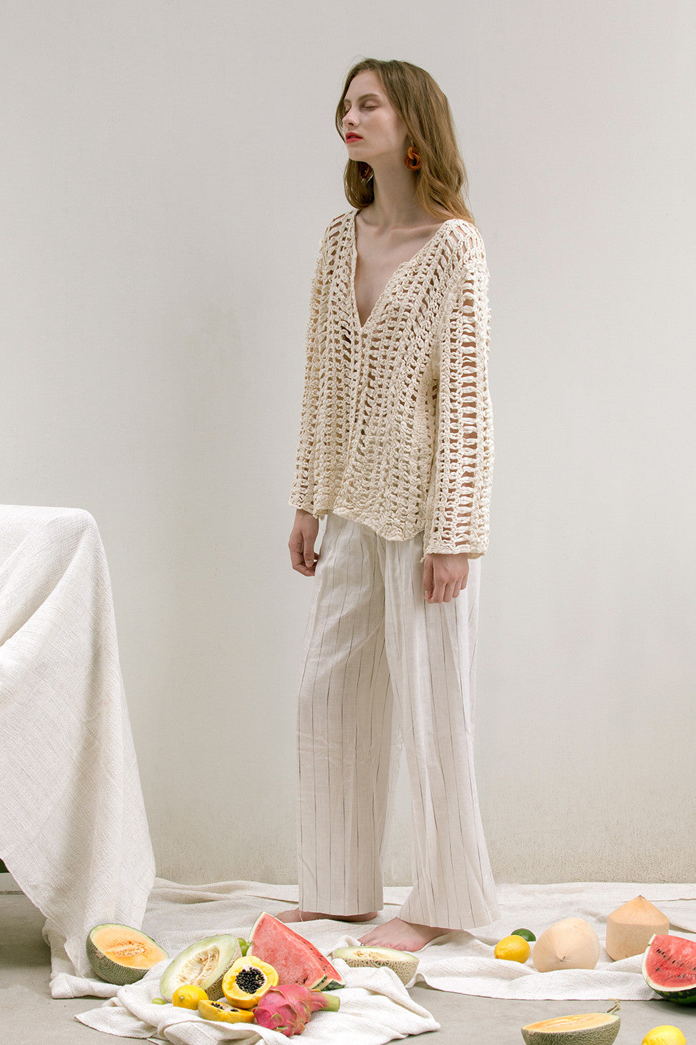 The Loe fishnet knit in Ivory featuring deep V-neckline, long sleeves. Pull on. Comfortable silhouette. 