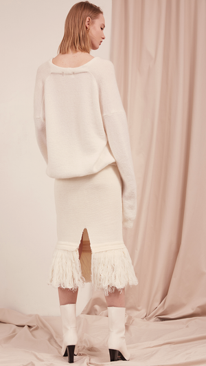 The Losara Skirt in ribbed knit off-white. With gathered elastic waistband, tassels hem, deep v back slits. 