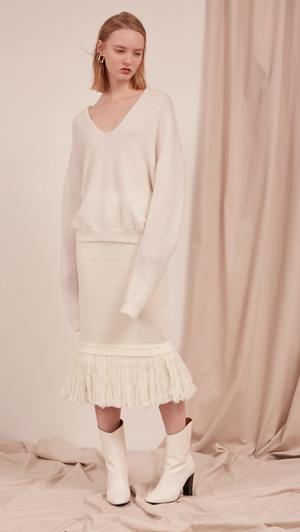 The Losara Skirt in ribbed knit off-white. With gathered elastic waistband, tassels hem, deep v back slits.