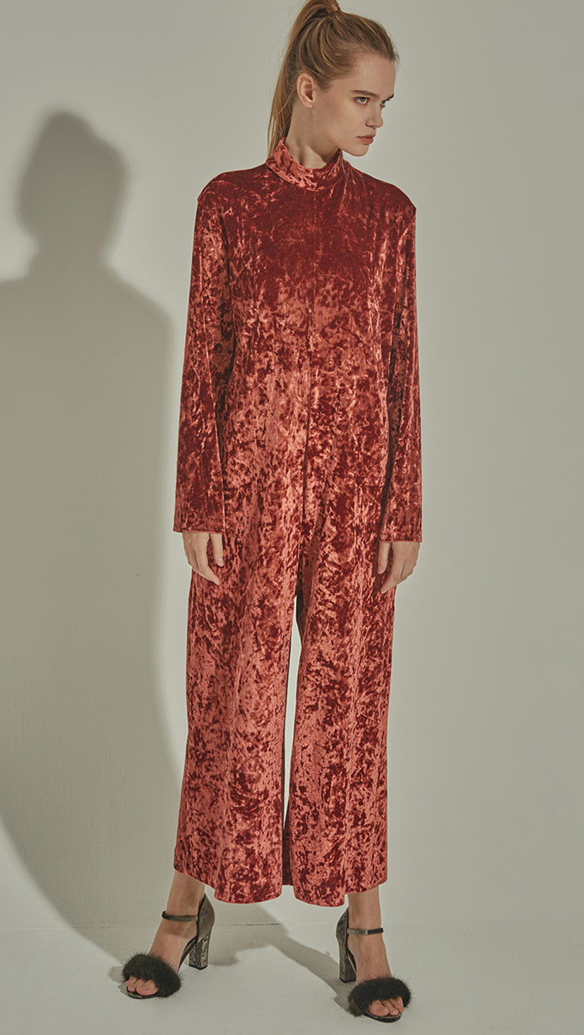 The Lynn is a loose fit jumpsuit in lustrous velvet. With a turtleneck collar, long sleeves and concealed zip closure at back. Russet Brown. Relaxed fit.