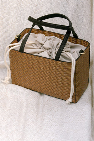 Mamba bag in Brown. Woven straw basket bag with fabric insert. Top handles. Detachable shoulder straps. 