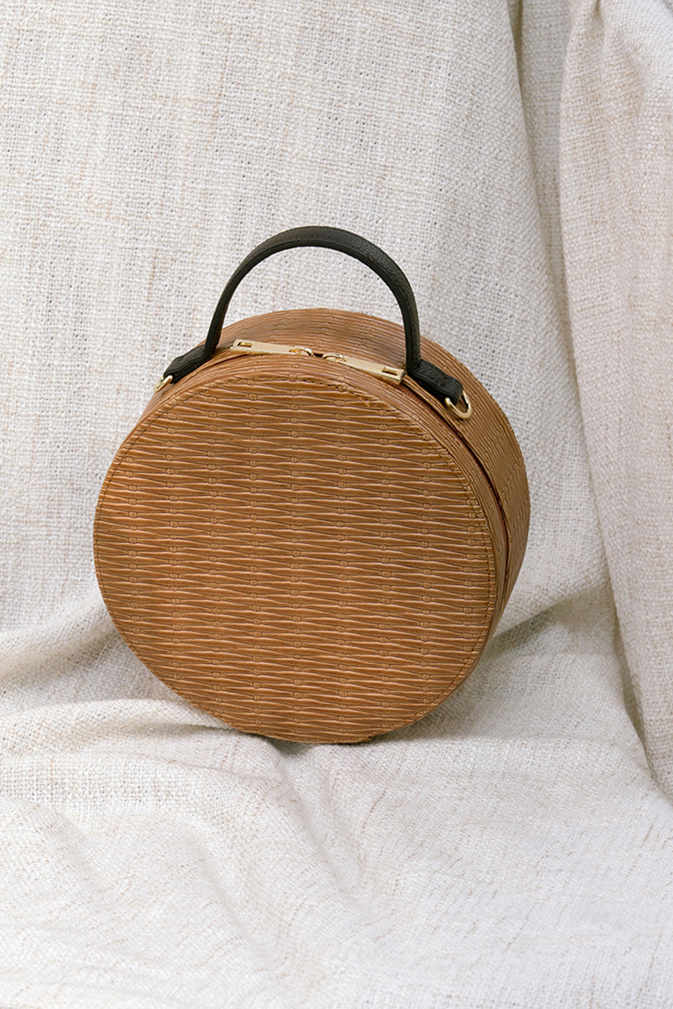 Marais bag in Brown. Woven round straw basket bag with fabric insert. Top handles. Detachable shoulder straps. 